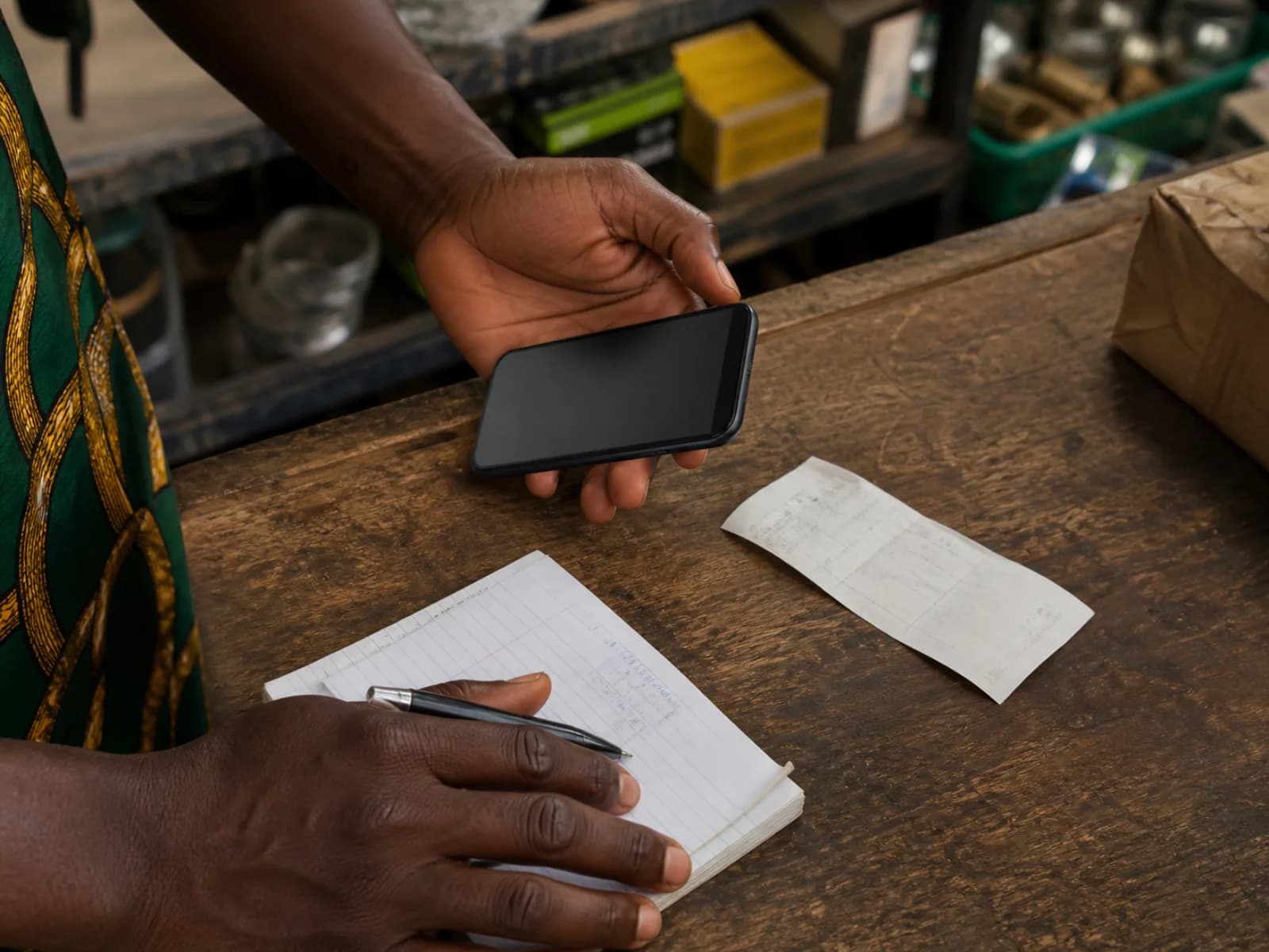 A trader checking a photographed receipt before adding it to a business record